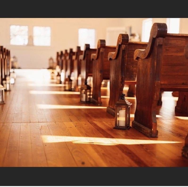 Morning sun across the heart-pine floor and the ends of the old pews, a lantern at each row