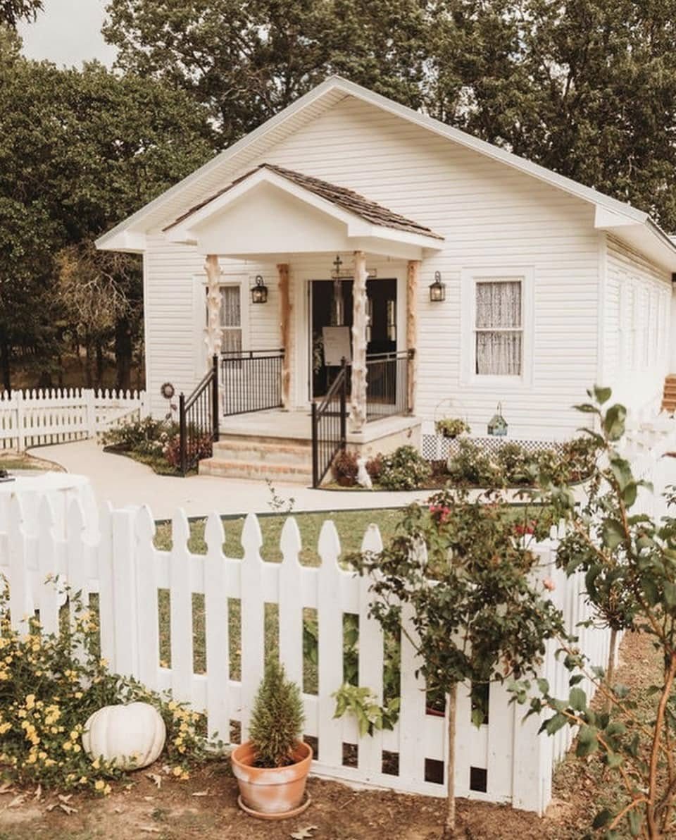 The white chapel behind its picket fence, cedar-post porch and wreaths on the double doors